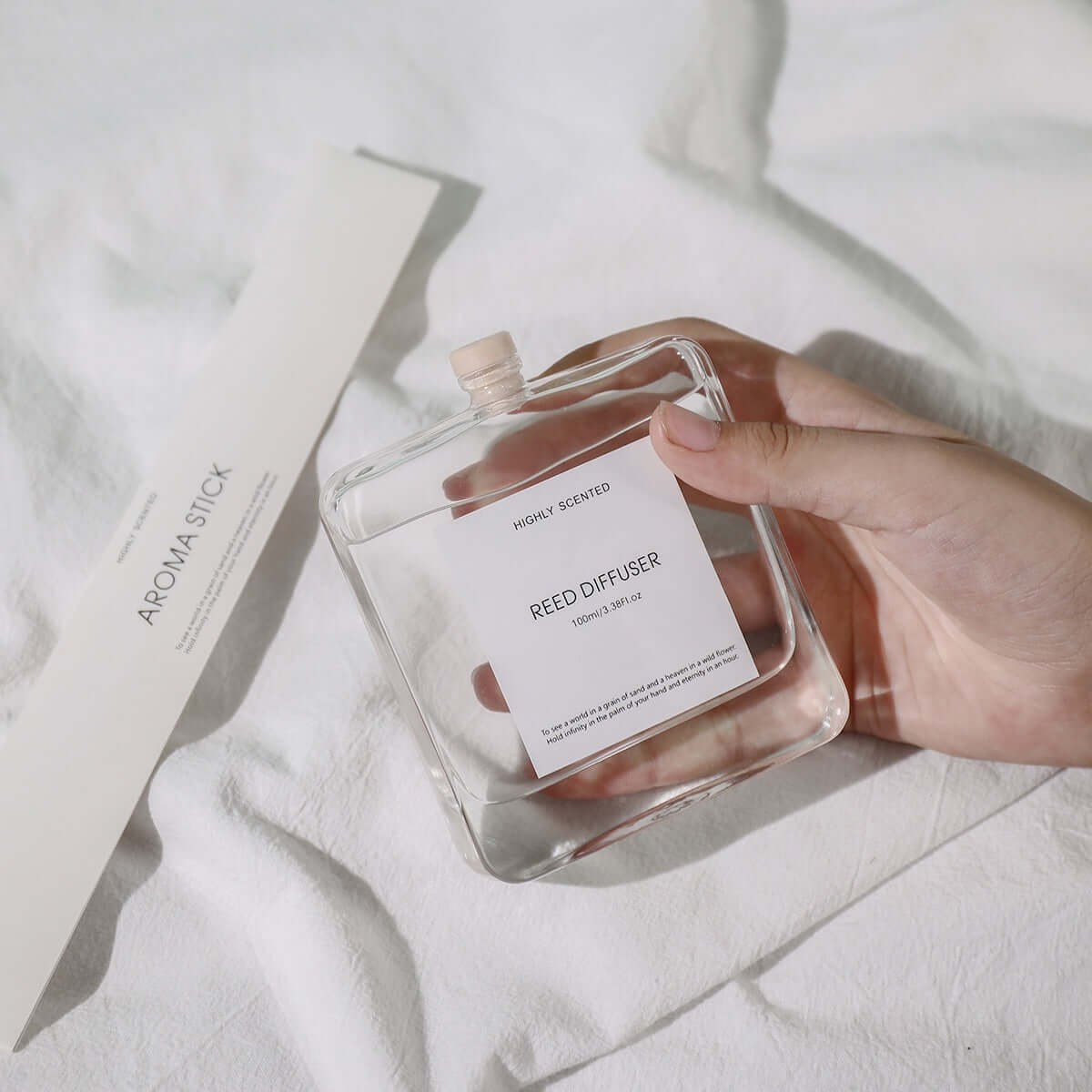 Plant-Inspired Indoor Bedroom Fragrance reed diffuser held in hand with aroma stick on soft surface.